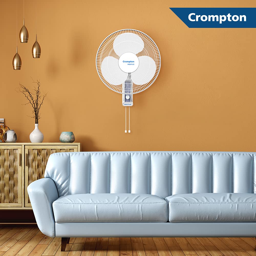 Crompton wall fan mounted on a mustard yellow wall above a light blue sofa.